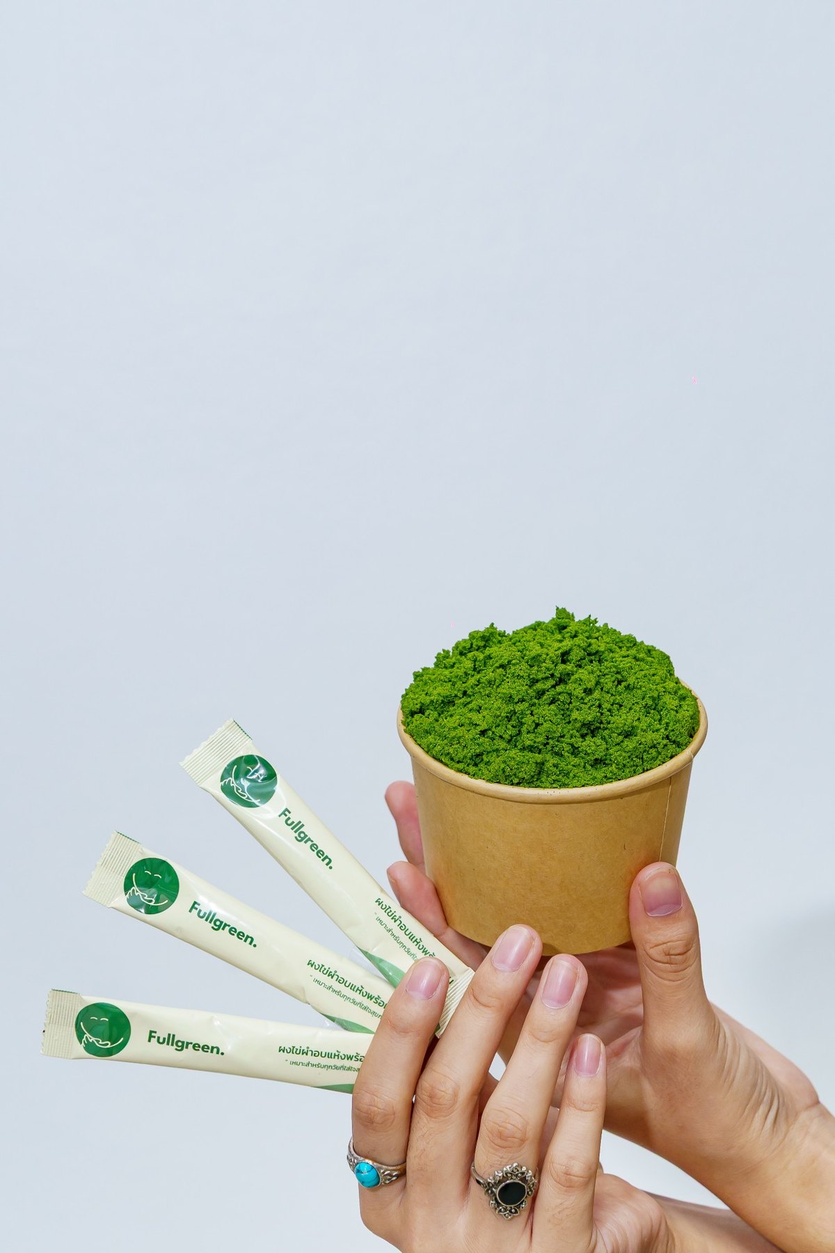 Fresh Wolffia cup held with sachets